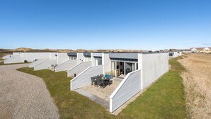 Moderni rakennus, jossa on useita kerroksia ja katettu ulkotila istumista varten.