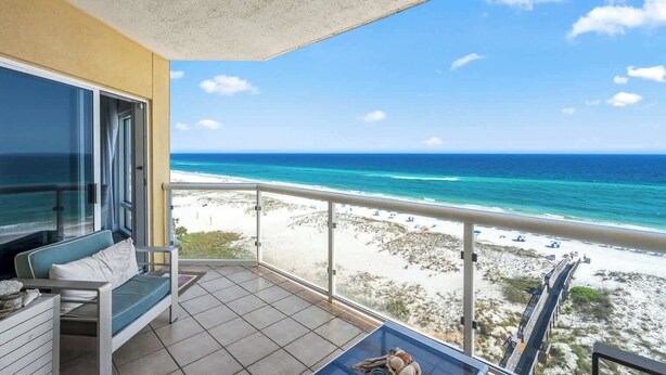 A balcony with a view of a beach and ocean.
