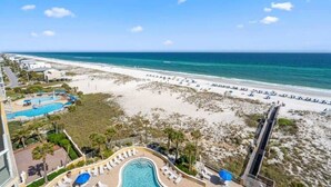 A resort with a pool, beach, and ocean view.