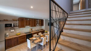 A modern kitchen with wooden cabinets, a dining table set for four, and a staircase with a metal railing. - Amazing home in Barban (Barban)