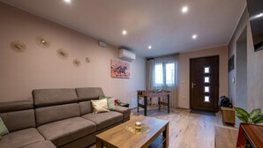 A living room with a sofa, a coffee table, a foosball table, and a door with a window. - Amazing home in Barban (Barban)