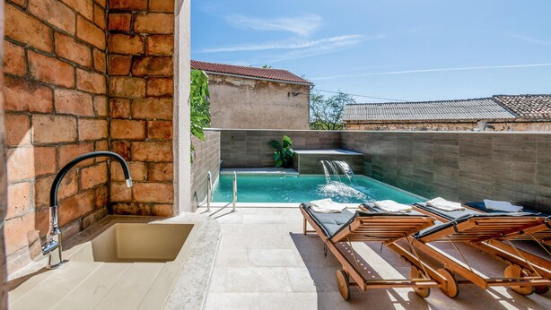 A rooftop pool area with a brick wall, a built-in hot tub, and lounge chairs. - Amazing home in Barban (Barban)