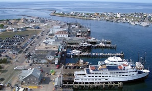 Un quai pour les traversiers, avec un grand navire amarré, un parking et un petit bâtiment.