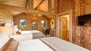 Ein Blockhauszimmer mit zwei Betten, einer Essecke und einer Küche.