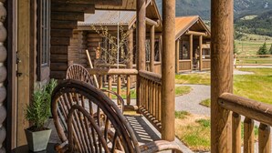Eine Holzhütte mit Veranda, einem Stuhl und einem Blumentopf.
