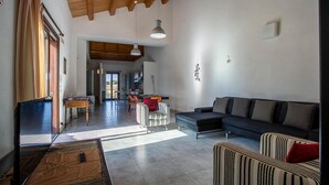 A spacious living area with a dark sofa, striped armchairs, and a wooden ceiling. - Pet friendly home in Ragusa (Ragusa)
