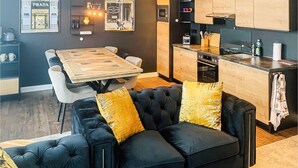 Uma cozinha moderna com armários de madeira, forno embutido e área de refeições com mesa e cadeiras de madeira.