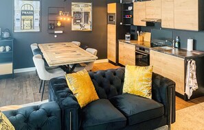 A modern kitchen with wooden cabinets, a built-in oven, and a dining area with a wooden table and chairs. - Nice apartment in Mettmann with WiFi (Mettmann)