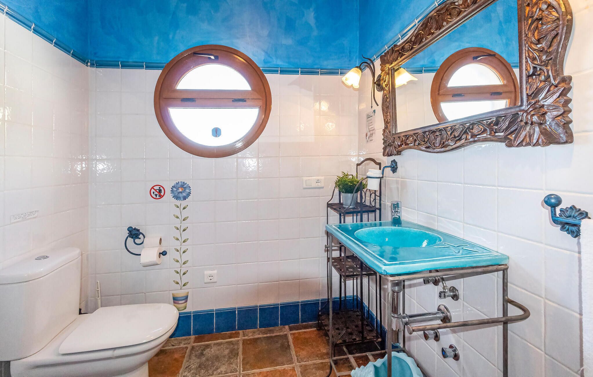 Une salle de bain avec des toilettes, un lavabo et un miroir.