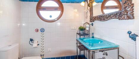 Une salle de bain avec des toilettes, un lavabo et un miroir.