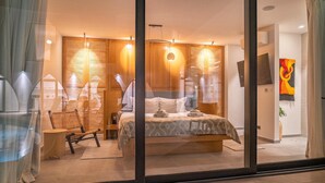 Ein modernes Schlafzimmer mit einem Bett, einem Sessel und einem kleinen Tisch.