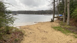 A sandy beach path leading to a lake with boats, surrounded by trees and a forest in the background. - Lakefront, Wooded, & Secluded Home - Family Dogs Welcome. (Oakland)