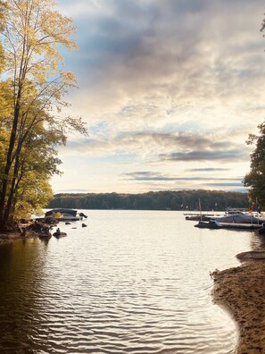 A lake with boats docked on the shore, surrounded by trees and a cloudy sky. - Lakefront, Wooded, & Secluded Home - Family Dogs Welcome. (Oakland)