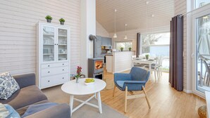 Ein gemütliches Wohnzimmer mit Kamin, Essbereich und Küche.