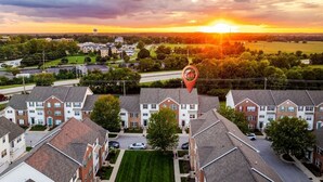 Zona residencial con casas, una carretera y un atardecer.