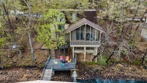 A house with a deck, surrounded by trees and a swimming pool. - Lake front property with huge dock connected to Margaritaville (Osage Beach)