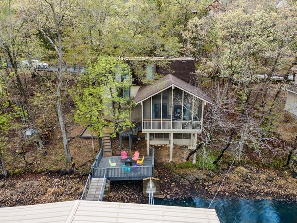 A house with a deck, surrounded by trees and a swimming pool. - Lake front property with huge dock connected to Margaritaville (Osage Beach)