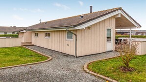 A single-story building with a sloped roof, a small porch, and a gravel driveway. - Nice home in Sydals with sauna (Sydals)