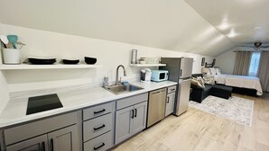 A compact kitchen with a sink, microwave, and cabinets. - Studio apartment on the banks of Yellowstone River (Gardiner)