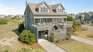 Une maison à deux étages dotée d’un balcon et d’une terrasse couverte.