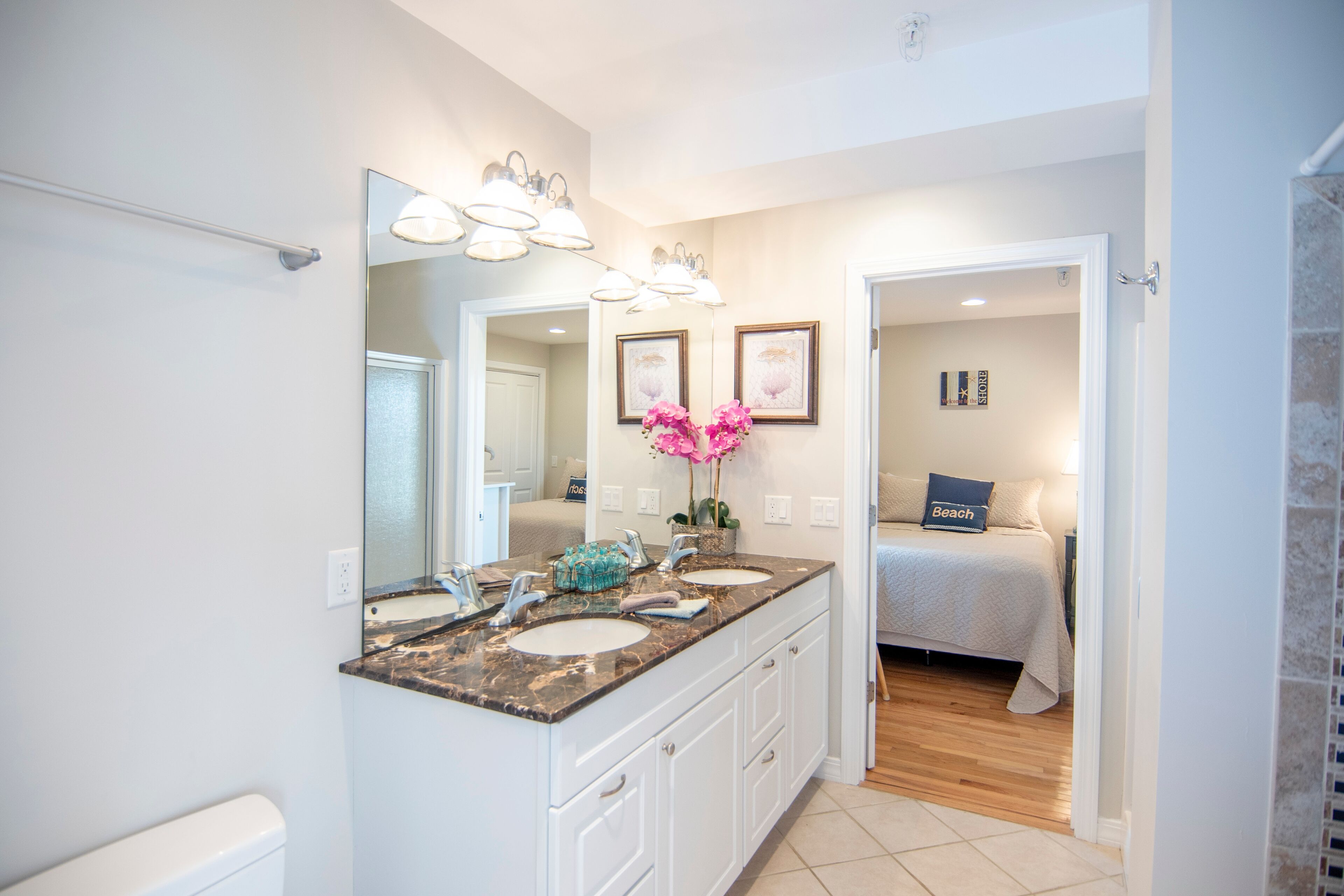 A bathroom with two sinks, a large mirror, and a vanity with drawers.