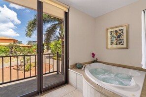 A room with a large bathtub, a sliding glass door leading to a balcony, and a framed artwork on the wall. - Standout Luxury Ocean View Villa (Playa Hermosa)