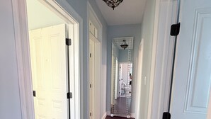 A hallway with white doors, a dark carpet, and a ceiling light fixture. - 1 Block from Cape May Beach & 10 min. walking distance to mall-3rd Floor Unit (Cape May)