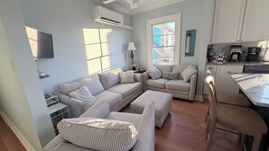 A living room with a sectional sofa, a dining area with a kitchen in the background, and a ceiling fan. - 1 Block from Cape May Beach & 10 min. walking distance to mall-3rd Floor Unit (Cape May)