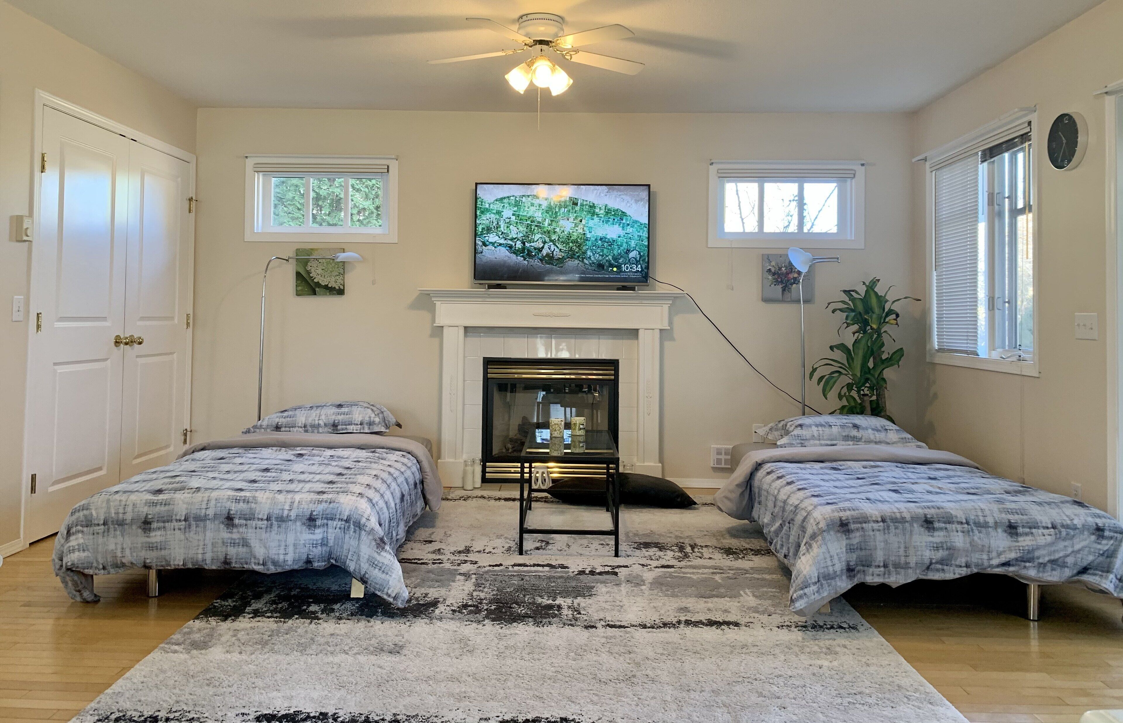Un dormitorio con dos camas, chimenea, televisor y ventilador de techo.