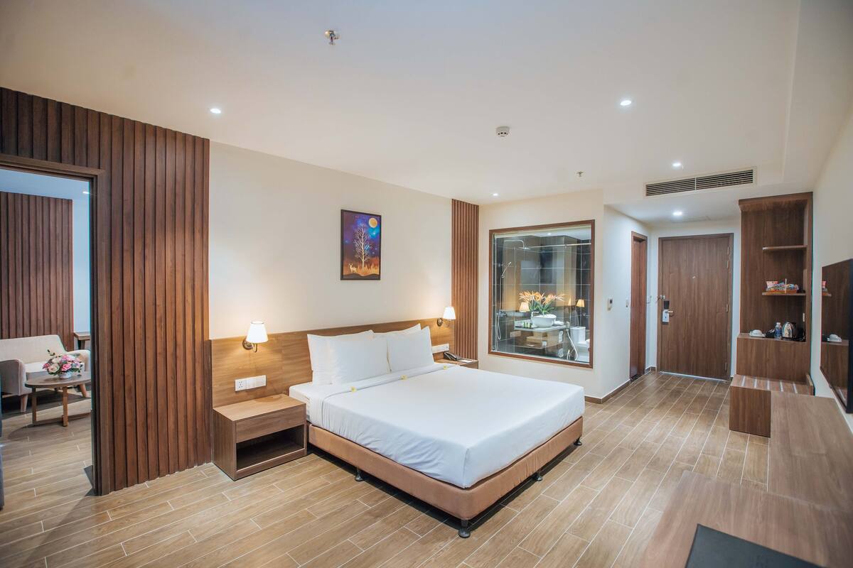 Een moderne hotelkamer met een groot bed, nachtkastjes, een bureau en een kledingkast.