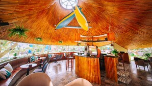 A restaurant with a unique bamboo ceiling, seating area, and a bar. - Celina Peninsula Resort (Dong Hoi)
