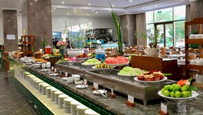 A buffet with various food items and a seating area with tables and chairs. - Celina Peninsula Resort (Dong Hoi)