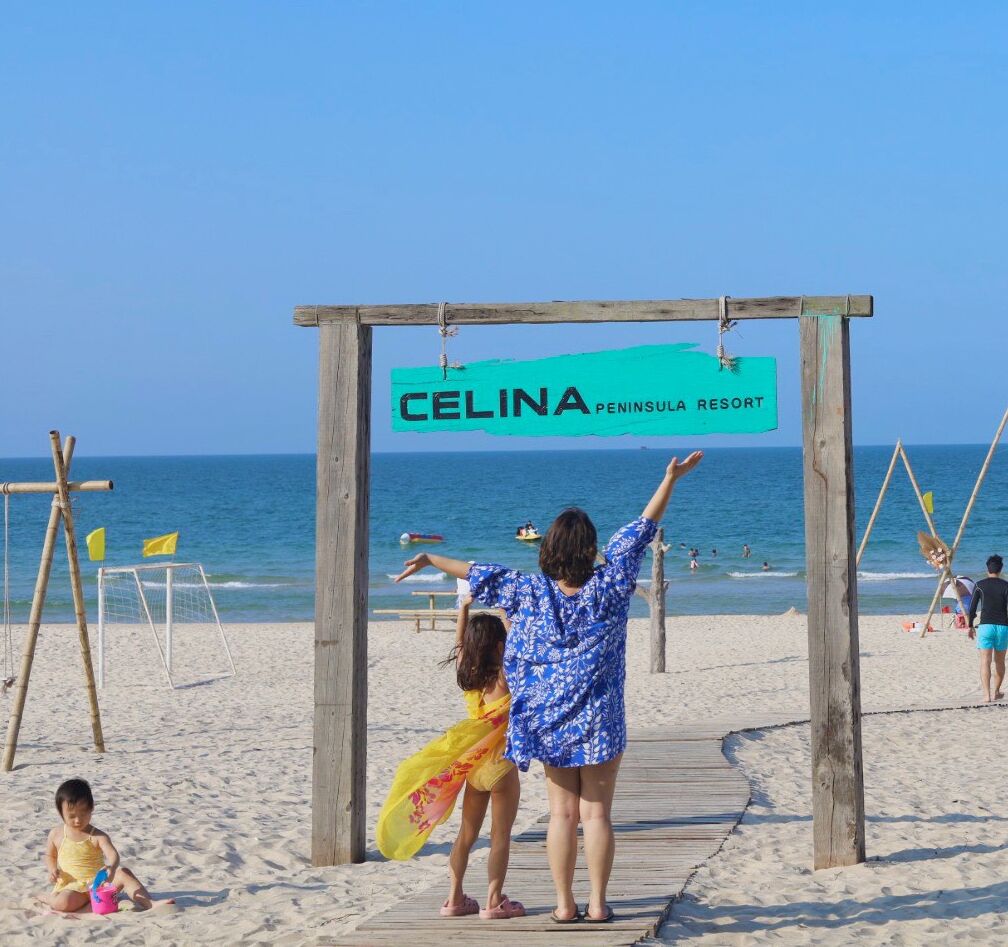 A wooden archway with a sign reading "CELINA PENINSULA RESORT" at a beach.