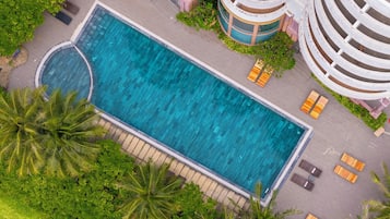 Una piscina al aire libre, sillones reclinables de piscina