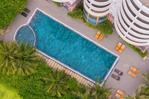 Una piscina al aire libre, sillones reclinables de piscina