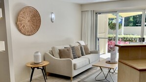 Ein Wohnzimmer mit einer Couch, einem kleinen Tisch und einem Wanddekor.