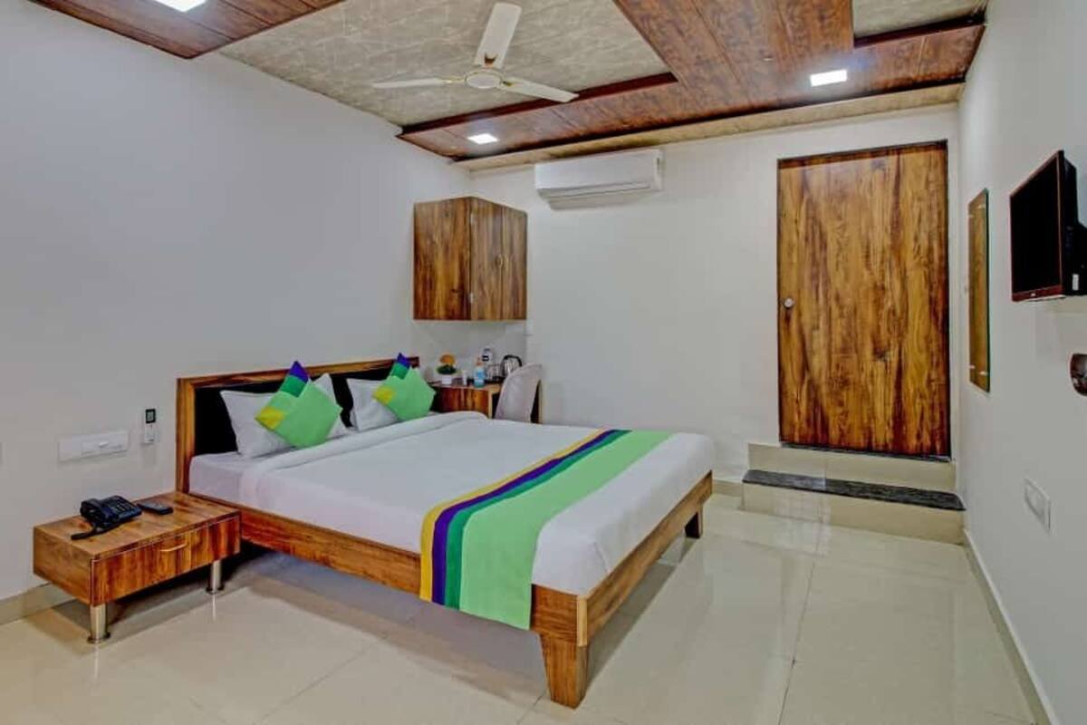 A bedroom with a wooden bed, a nightstand, a wardrobe, and a ceiling fan.