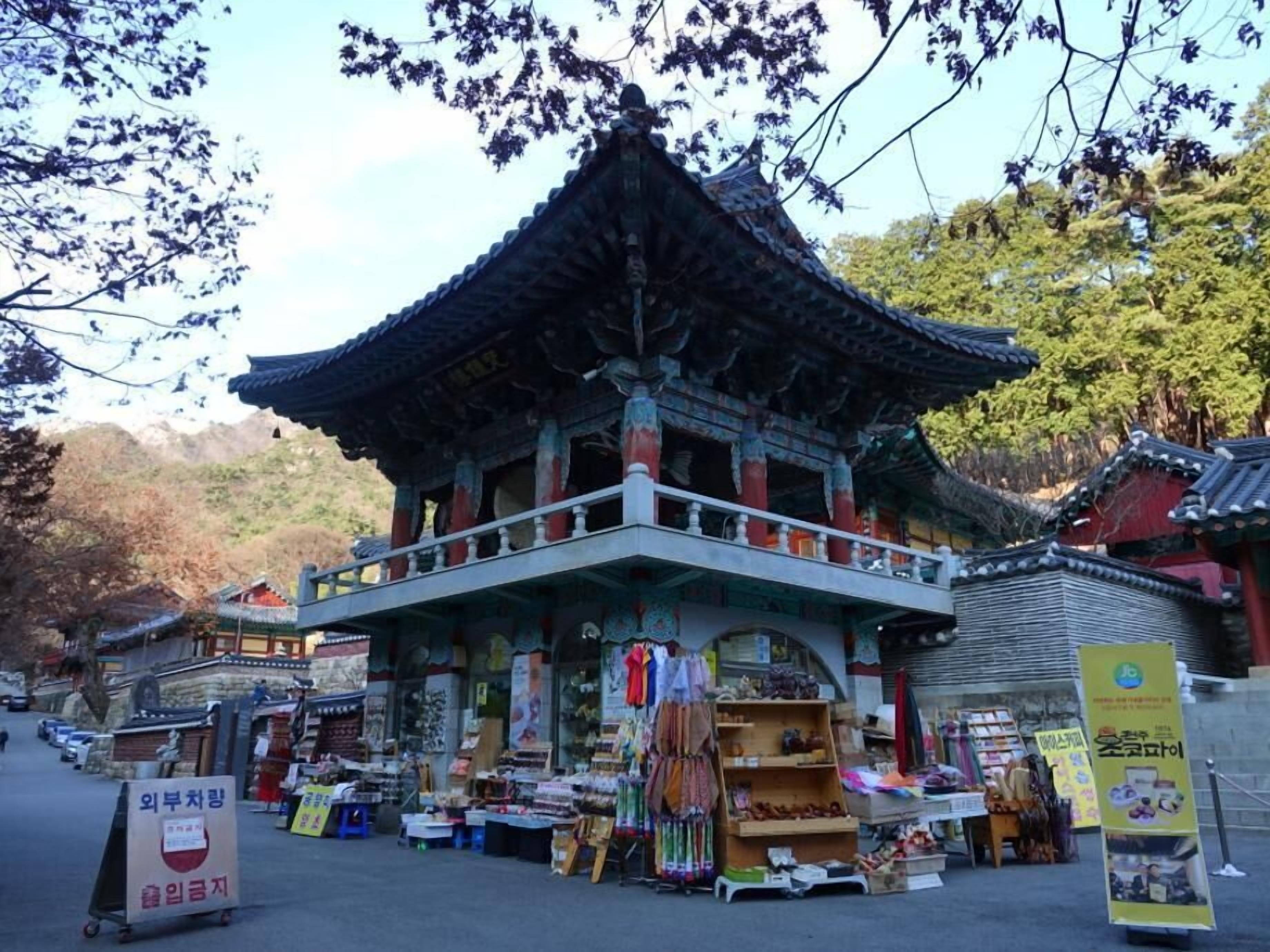 A traditional Korean building with a tiled roof and a balcony.