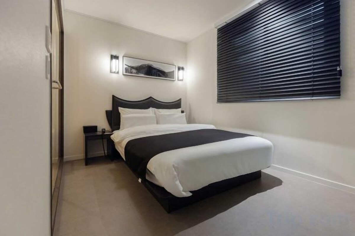 1 dormitorio, ropa de cama de alta calidad, escritorio y cortinas opacas