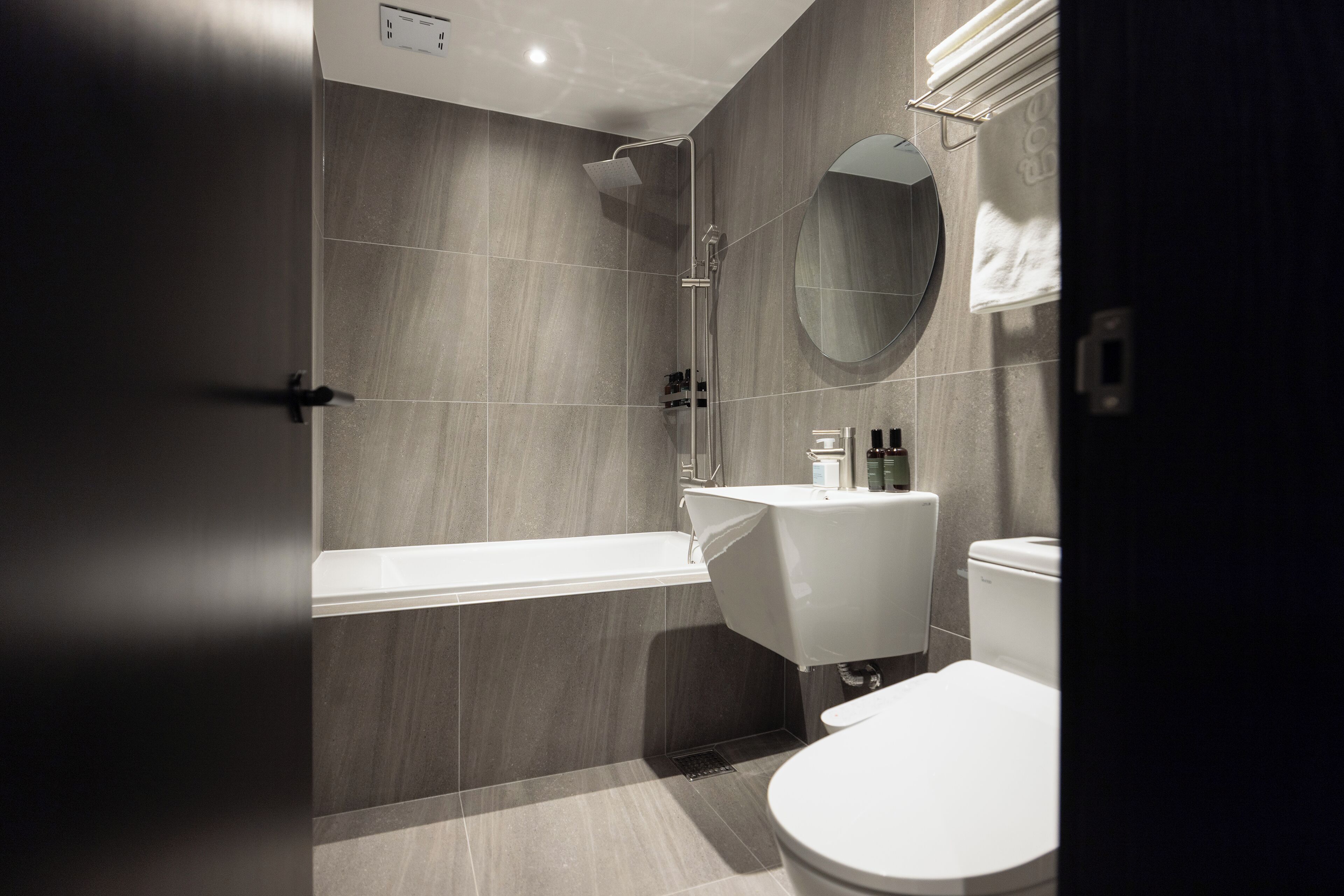 A modern bathroom with a bathtub, toilet, and sink.