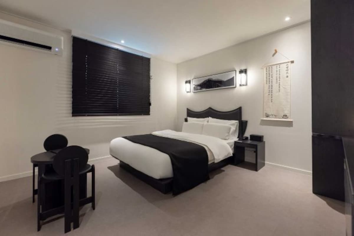 Une chambre à coucher moderne avec un grand lit, un bureau et une chaise.