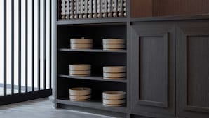 A modern kitchen with dark wood cabinetry, a built-in shelf unit with wooden bowls, and a large window with vertical blinds. - Anook Hotel and Spa Daejeon Yuseong (Daejeon)