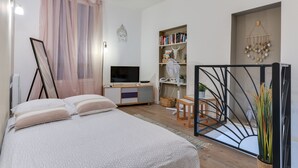 Une chambre à coucher comprenant un lit, une table de chevet, une bibliothèque et un téléviseur.