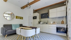 Une cuisine compacte avec un coin repas, un canapé et un sol carrelé.