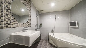 A modern bathroom with two sinks, a large mirror, a shower, and a television mounted on the wall. - Busan Deokcheon Den Basta Hotel (Busan)