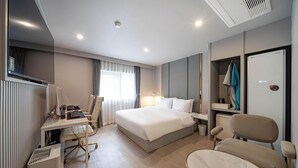 A modern hotel room with a large bed, a desk with a computer, a chair, and a wardrobe. - Busan Deokcheon Den Basta Hotel (Busan)