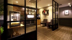 Un interior moderno con mostrador de recepción, zona de estar y una vitrina con artículos.