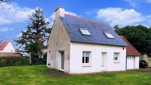 A single-story house with a sloped roof, a chimney, and a small front yard. - Beachside House with Garden & WiFi, 400m from Shore in Pleumeur-Bodou (Pleumeur-Bodou)