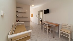 A room with a bed, a desk, and a chair. - Natassa Apartments, 2 Bedrooms 30m from sea (Kefalonia)