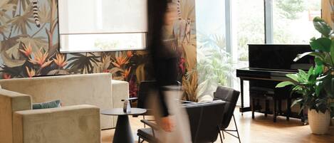 Una sala de estar moderna con un sofá, una mesa de centro, un piano y plantas colgantes.